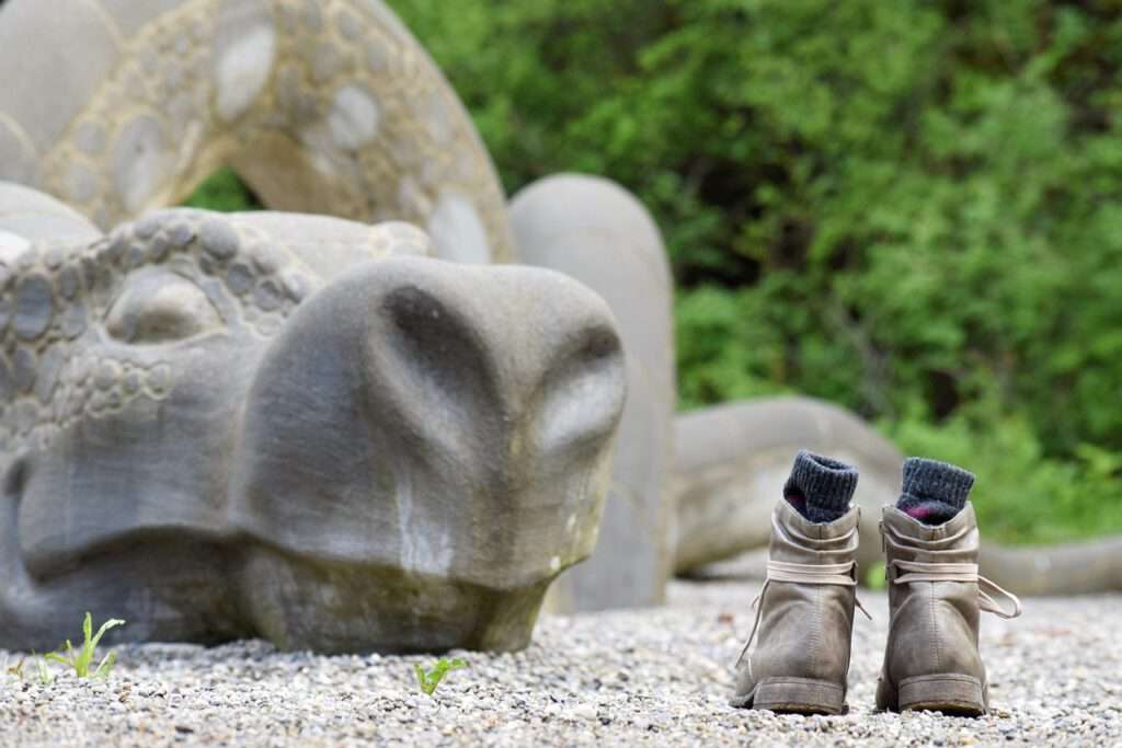 Steinerner Drache mit Schuhen und Strümpfen davor